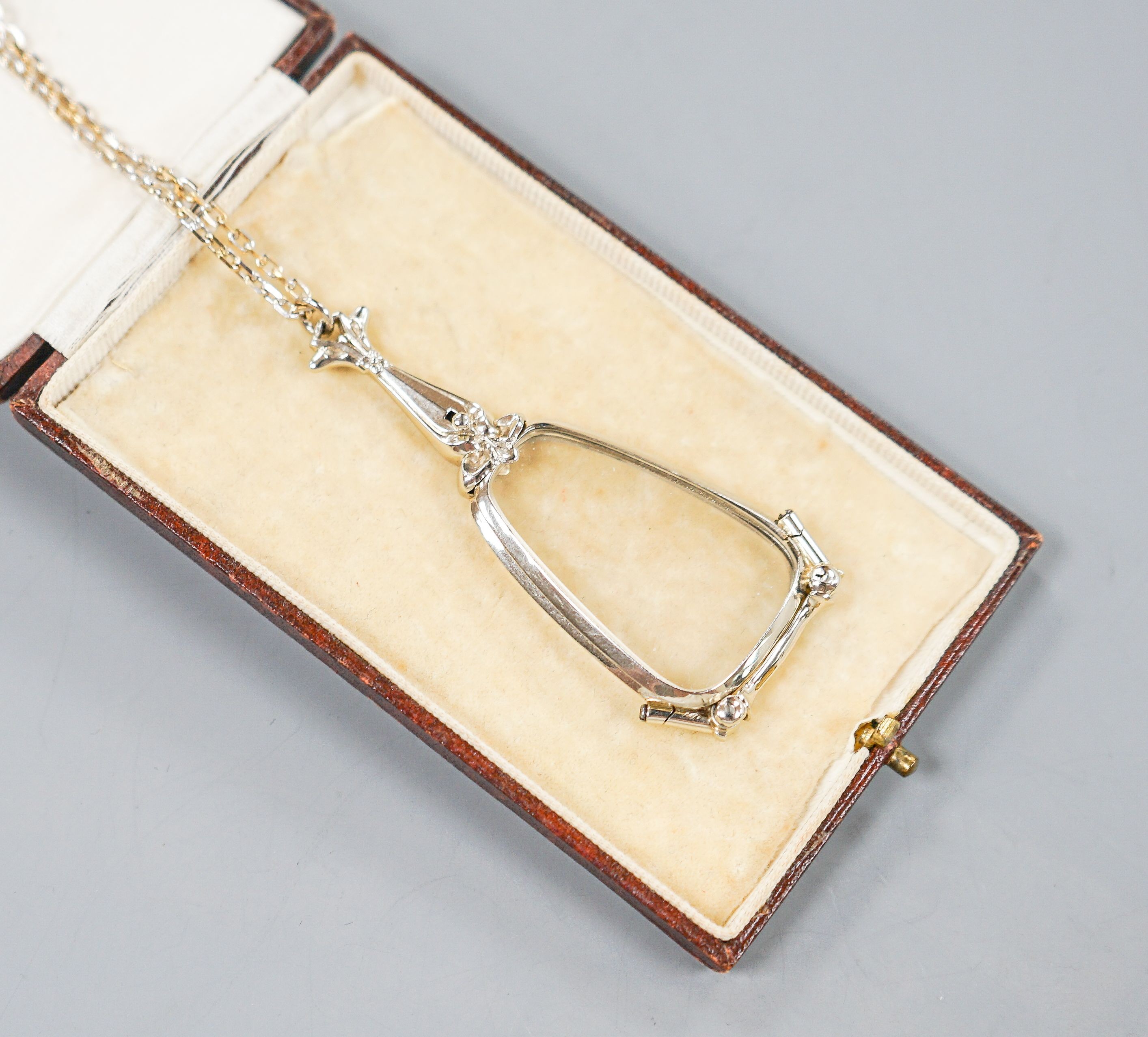 A modern 14k white mounted lorgnettes, 62mm, gross 14.1 grams, on a modern 750 white metal chain, 80cm, 14 grams.